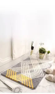 Détail du tapis de bain géométrique en peluche avec bords antidérapants et haute absorption