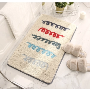 Détail du tapis de bain beige moelleux aux motifs de vagues sur sol en marbre blanc