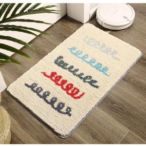 Détail d'un tapis de bain doux et épais avec motifs de vagues colorés et bordure grise