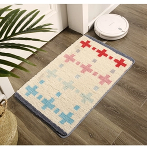 Détail du tapis de bain épais à motif géométrique sur un sol en bois clair