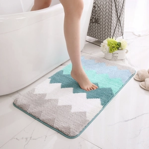 Tapis de bain absorbant avec motif ondulé bleu et gris près de la baignoire