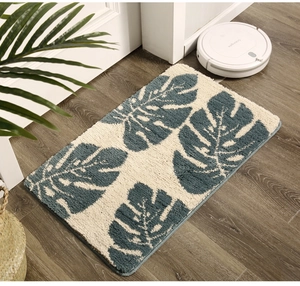 Close-up of blue monstera leaf rug texture on dark wood floor with home decor