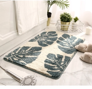 Detail of plush monstera leaf mat showing thick absorbent fibers on marble floor