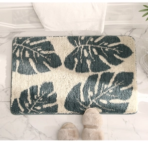 Macro detail of tufted monstera leaf bath mat with non-slip texture on marble floor