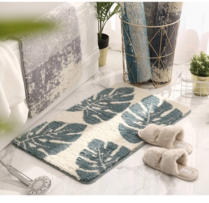 Detailed plush bathroom mat with grey leaf pattern on white marble bathroom flooring