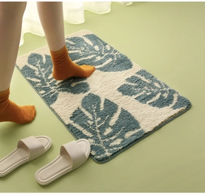 Detailed close-up of monstera leaf pattern rug with soft flocked texture and neat edging