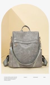 Detail of grey lychee textured PU leather backpack with gold accents and zipper flap