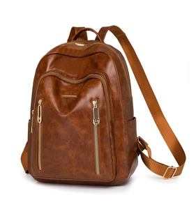 Macro detail of dark brown vintage leather backpack with golden zippers and fabric straps