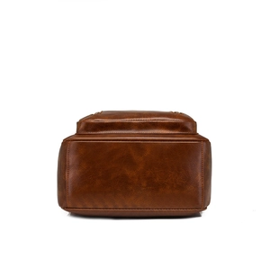 Detailed bottom view of brown faux leather backpack with litchi texture and neat stitching