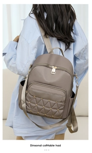 Detail view of khaki Oxford fabric backpack with diamond quilting and gold rivets