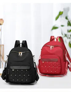 Detail of red and black quilted oxford backpacks with golden rivet studs and pockets
