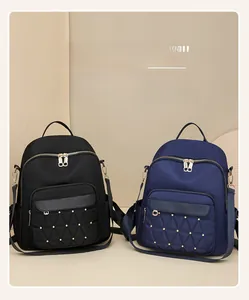 Detailed view of Oxford fabric backpacks with quilted pockets and gold stud accents