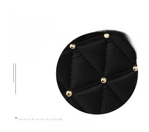 Detail of black quilted oxford fabric backpack featuring golden spherical rivet studs