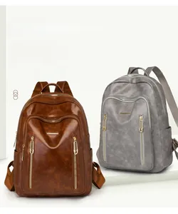 Close-up of brown and gray large capacity leather backpacks with multi-zipper compartments