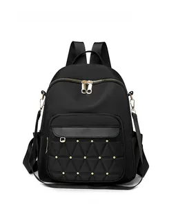 Front view detail of black oxford backpack with quilted diamond pattern and gold rivets