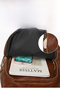 Detail view of the brown leather backpack front zipper pocket showing its large capacity