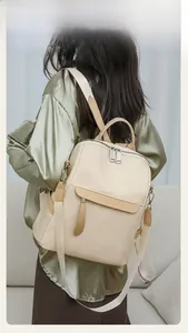 Rear view of cream Oxford fabric backpack worn by a model in a minimalist home setting