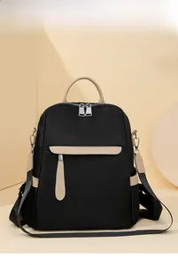 Macro shot of large black oxford fabric backpack showing beige leather handle and zip detail