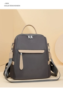 Detail of grey Oxford fabric backpack with beige leather accents and adjustable straps