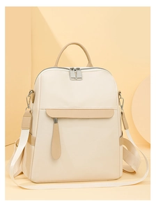 Close-up of cream oxford backpack showing zipper pockets and waterproof fabric details