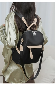 Detail of a beige and black high-density nylon backpack worn on back for size reference