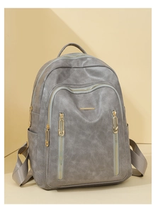 Detailed side view of grey leather backpack with golden zippers and natural texture