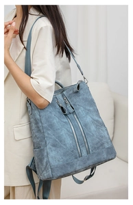 Side view of a vintage blue multi-functional backpack on model in a minimalist room setting