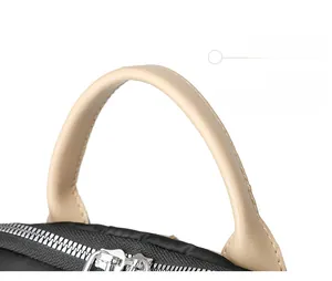 Close-up of black oxford travel bag showing high-quality beige leather handles and metal zippers