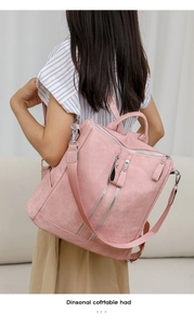 Close-up of pink minimalist backpack with dual silver zippers and matte texture detail