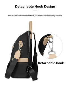 Detail of detachable silver metal hook and khaki leather trim on black oxford backpack
