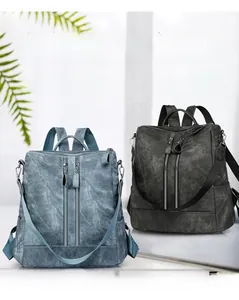 Detail view of stylish multi-pocket faux leather backpack in blue and dark grey colors