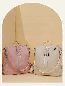 Detail view of pink and beige backpacks featuring double zippers and internal compartments