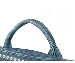 Detailed close-up of blue canvas bag handle and silver metal zipper on a white background