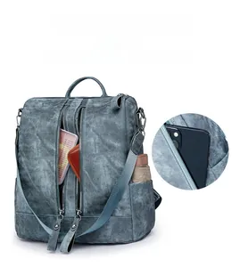 Close-up of blue wash denim backpack showing functional side pockets and front dual zippers