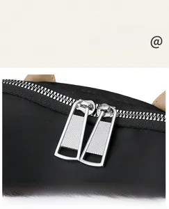 Close-up of premium silver metal double zippers on a black oxford travel backpack