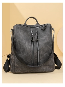 Detail view of dark grey multifunctional backpack with dual vertical zippers and soft leather texture