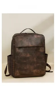 Detailed view of deep brown vintage PU leather texture and front zipper pocket on backpack