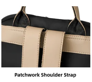 Detail of reinforced stitching and beige leather accents on a black oxford shoulder bag