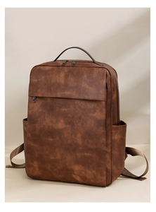 Detailed view of brown vintage leather backpack with textured finish and side pockets