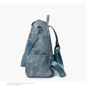 Side view of blue washed canvas backpack showing large capacity and adjustable straps