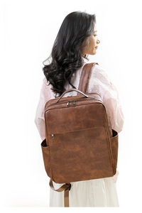 Detailed side view of vintage brown PU leather backpack with side pockets and straps