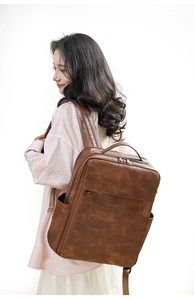 Brown vintage PU leather backpack worn by a model, showcasing large capacity and texture