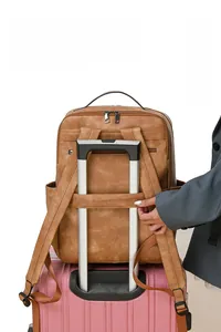 Brown PU leather backpack featuring a luggage strap for easy attachment to suitcases