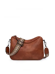 Front view of red-brown crossbody bag with bohemian style colorful woven shoulder strap