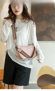 Pink faux leather crossbody bag with a colorful ethnic style woven shoulder strap