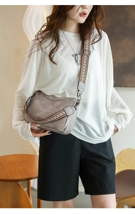 Detail of taupe crossbody bag with an ethnic style woven wide shoulder strap on model
