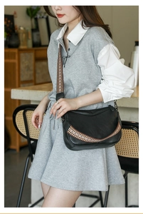 Detail of black crescent crossbody bag with colorful bohemian geometric wide strap