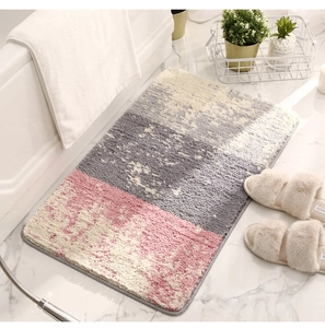 Détail du tapis de bain en microfibre rose et gris avec texture douce antidérapante