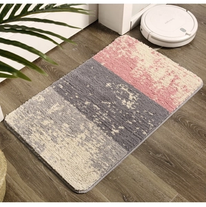 Détail du tapis de bain floqué montrant la texture microfibre et le patchwork bicolore