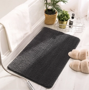 Close-up of deep grey high-density fiber bathroom mat on white marble floor